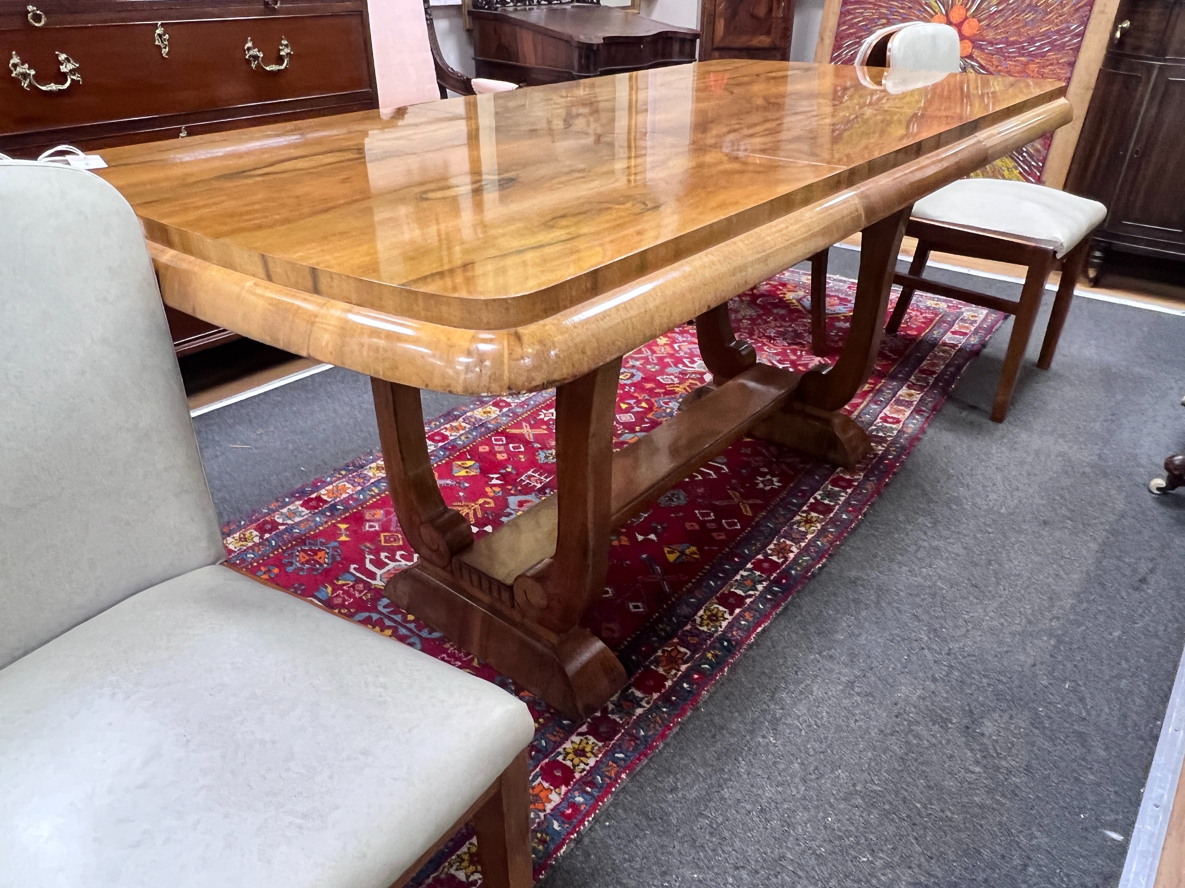 An Art Deco style walnut extending dining table, length 170cm extended, width 80cm, height 77cm and four chairs